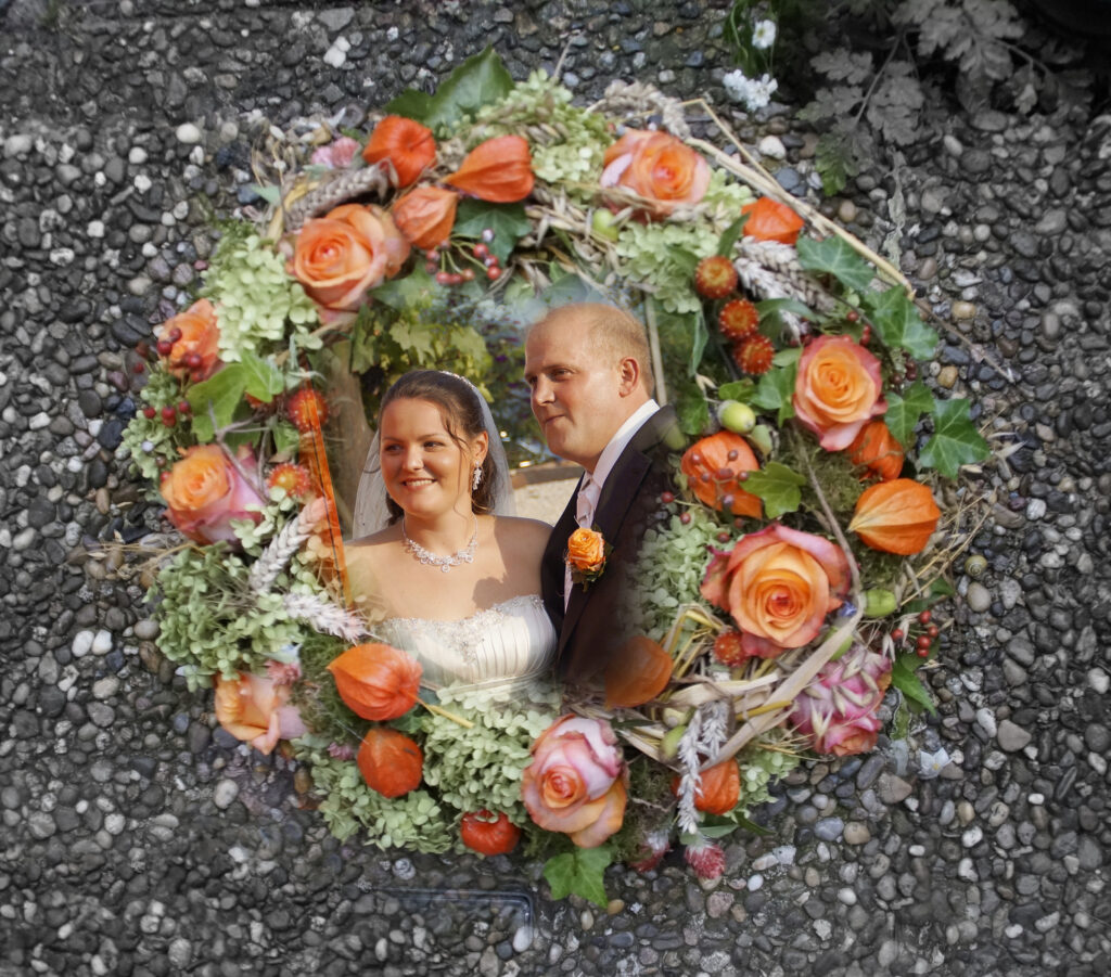 Ein auf Waschbeton liegender Kranz zeigt im Innenteil das Foto des Brautpaares